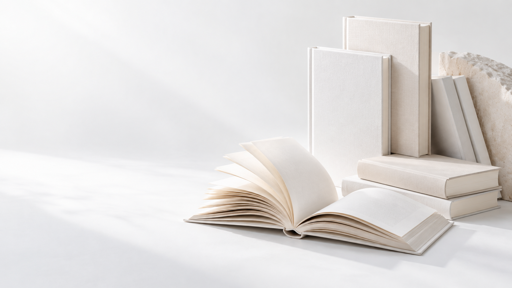 An open book beside a stack of hardback books